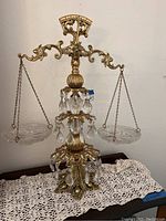 Full view of the vintage glass and brass decorative scale showing glass trays on brass chains and hanging crystal-like pendants.