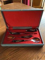 Four-piece Middle Eastern carving set in original box, showing all utensils neatly placed on red fabric lining.