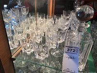Overall view of the set showing multiple glasses and the decanter on a glass shelf with mirror backing.