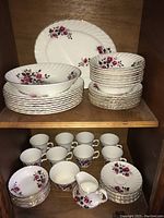 Full view of china sets with cups, bowls, plates, saucers, and cream pitcher