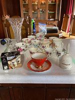 Overview of entire lot placed on a table, showing all cups, mugs, vase, cruet, and boxed salt and pepper shakers.