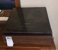 Top view with plastic dust cover in place showing Sony logo and wood grain case