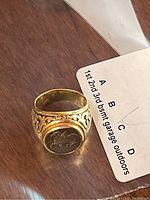 Top-front view of ring showing bezel-mounted Pegasus coin and filigree shoulders