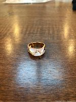 Front view of wide gold band showing mother-of-pearl inlays and diamond accents