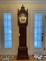 Full front view of the tall wooden longcase clock showing hood, trunk and base.