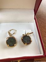 Pair of shipwreck coin earrings in 14K gold leverback settings displayed in box