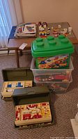 Overall view of wood table, storage containers of Lego bricks and manuals