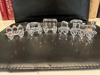 Front view of all five crystal train pieces in a row on black surface