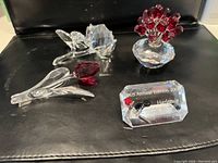 All three flower figurines and plaque arranged on black surface