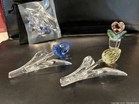 Overview of two full-size tulip figurines, potted heart bud figurine, and sealed bag of miniature flowers on black background