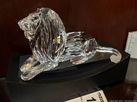 Side view showing profile of crystal lion and black pedestal