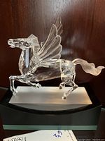 Front view of clear crystal Pegasus on black and frosted glass pedestal