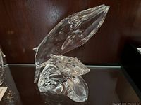 Front view of crystal whales leaping from wave base