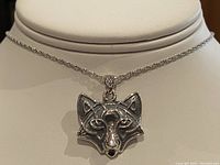 Close-up of wolf head pendant showing detailed face and bail attachment.