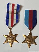 Front view of two British Commonwealth six-pointed bronze campaign medals from 1945 with distinct ribbon colors