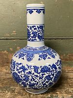 Front view of vase on carved wooden stand showing overall appearance and decoration