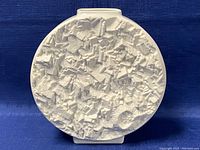Front view of round white bisque vase with abstract textured surface