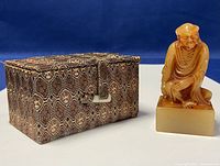 Seal and presentation box side by side against blue background