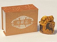 Photo of the miniature seal stamp next to its original box for size and condition reference