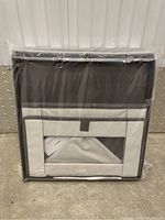 Three beige and gray fabric closet organizers stacked and packaged in plastic wrapping, showing front with transparent window and label