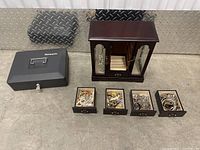 Overview showing black metal lock box, wooden jewelry box and four removed drawers filled with jewelry
