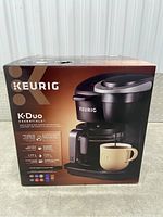 Photo of original Keurig K-Duo Essentials coffee maker box showing product image and branding.