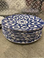 Stack of 8 melamine plates with blue and white geometric floral pattern.