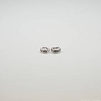 Two oval faceted morganite gemstones viewed from the front showing their clarity and cut.