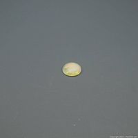 Oval cabochon opal gemstone displayed on a gray background, visible play of color and polished surface.