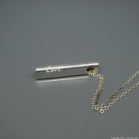 Image showing the silver bar pendant engraved with the word 'Care', attached to the silver chain.