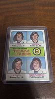 Front of Boston Bruins team leaders hockey card featuring Bobby Orr and Phil Esposito with player photos and stats.