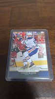 Front of Connor McDavid rookie hockey card showing player in game action.