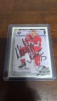 Front view of Nicklas Lidstrom Rookie Report hockey card signed with black marker, in plastic protective case.