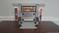 Front view of the WWE Raw Is War Titan Tron entrance playset showing the truss structure, screen with character images, vertical banners, and lights.