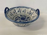Side angled view of the blue and white ceramic bowl showing decorative interior and one handle