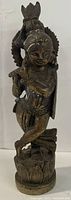 Front angle image of bronze-colored Hindu god figurine playing flute standing on lotus base