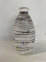 Front view of the clear Murano glass vase featuring black swirling lines and multicolored spots throughout its body.