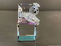 Front angle view of clear crystal clown Jack on rectangular box with black crystal dots at corners.