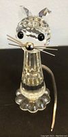 Front and top view of clear faceted Swarovski crystal mouse figurine showing metal whiskers, spherical silver nose, black eyes, large faceted ears, faceted cylindrical body, scalloped base, and metal coiled tail.
