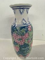 Front view of the vintage Asian porcelain vase showing hand-painted clusters of pink grapes and green leaves.