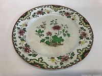Full view of vintage late 1800s decorative plate showing border and center floral designs.