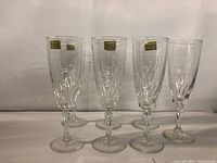 Seven Luminarc crystal champagne glasses displayed upright showing their clear crystal and cut pattern, with stems and bases visible.