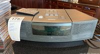 Front view of Bose Wave Radio CD player showing digital display and dust on surface.