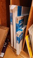 Five new stretched canvas panels stacked together in packaging, various sizes labelled including 11x14, 16x20 and 20x24 inches.