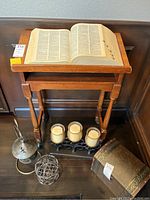 Full view of wooden stand with Webster’s dictionary open and unrelated items below