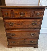 Front view showing all five drawers and metal pulls, minor surface scratches visible.