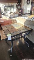 Front view of slate tile top end table near couch in living room.
