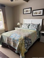 Full view of bed with headboard, bedding and mattress