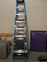 Full view of Werner 8' ladder upright in garage alongside stool and Little Giant ladder