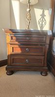 Front view of one nightstand showing two drawers and metal knob pulls